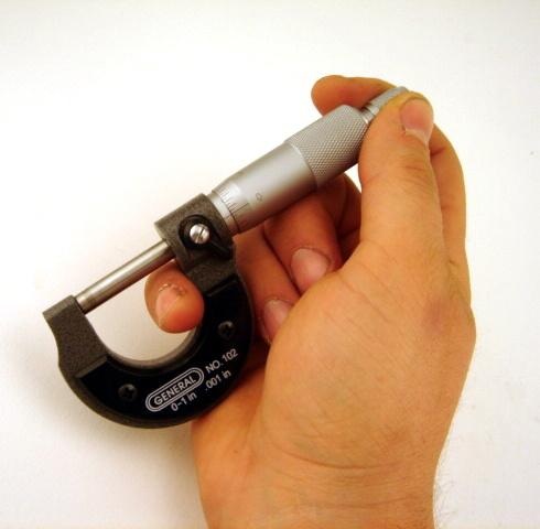 Analog Precision: General Tools 102 Graduation Micrometer Close-up of a General Tools 102 Graduation Micrometer in someone's hand, showcasing its clear graduation scale and ergonomic design.